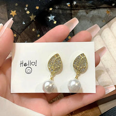 Model showcasing the dangle and style of the 14K Gold-Plated Luxury Zircon Tulip Pearl Earrings