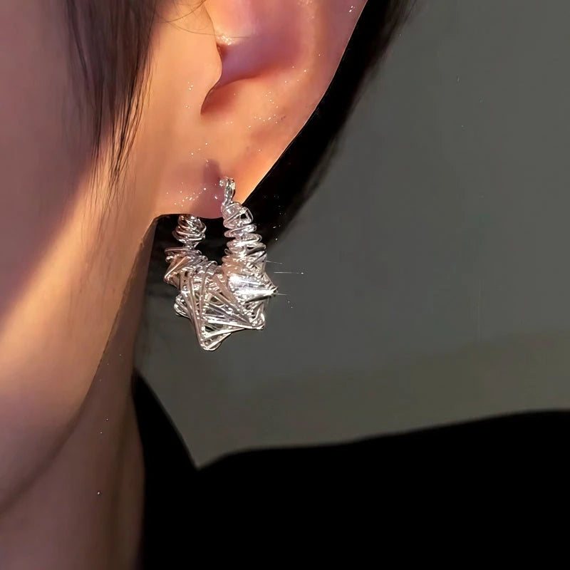 Model showcasing the dangle and style of the 14K Gold-Plated Matte Silver Winding Earrings