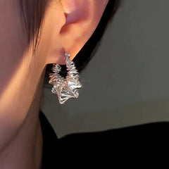 Model showcasing the dangle and style of the 14K Gold-Plated Matte Silver Winding Earrings