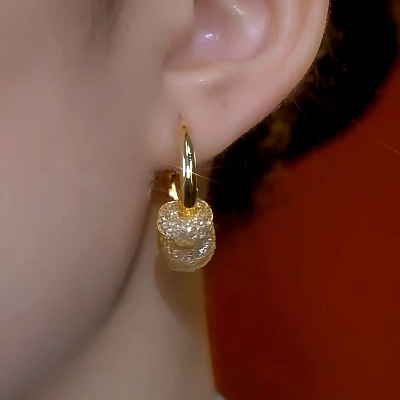 Side view of gold mesh crystal dangle hoop earring worn on ear
