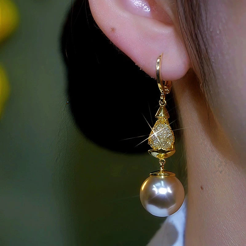 Close-up of gold pave teardrop pearl drop earring worn on ear