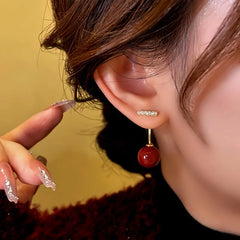 Side view of gold crystal bar red bead drop dangle earring on woman's ear