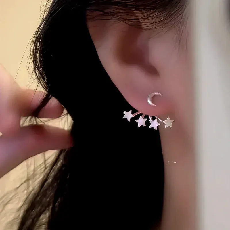 Silver crescent moon star stud earring, side view worn on ear with hair pulled back