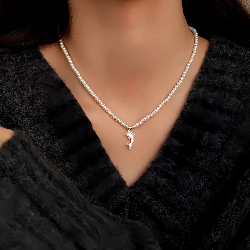 Women's dainty white pearl choker necklace with silver dolphin pendant