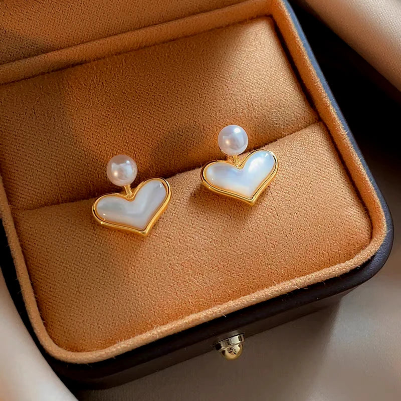 Dainty gold mother of pearl heart stud earrings with pearl accent in jewelry box