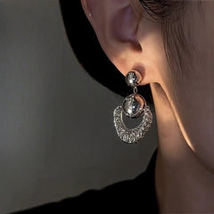 Side angle view of silver sparkly crescent dangle earring on ear