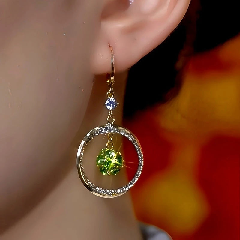 Model showcasing the dangle and style of the 14K Gold-Plated Multi-Layer Green Diamond Ball Zircon Hoop Earrings