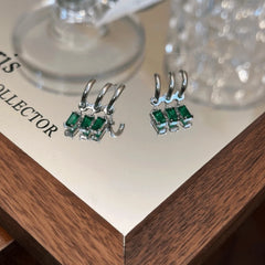 Angled view of the 14K Gold-Plated Multi-Layer Green Diamond Tassel Earrings