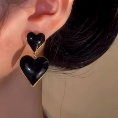 Model showcasing the dangle and style of the 14K Gold-Plated Oil Drop Double-Heart Earrings
