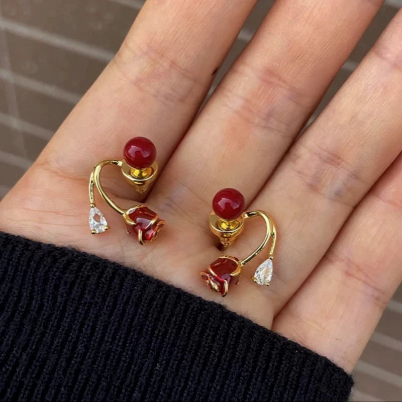 Pair of Red Rose Red Bead Gold Dangle Stud Earrings in Hand