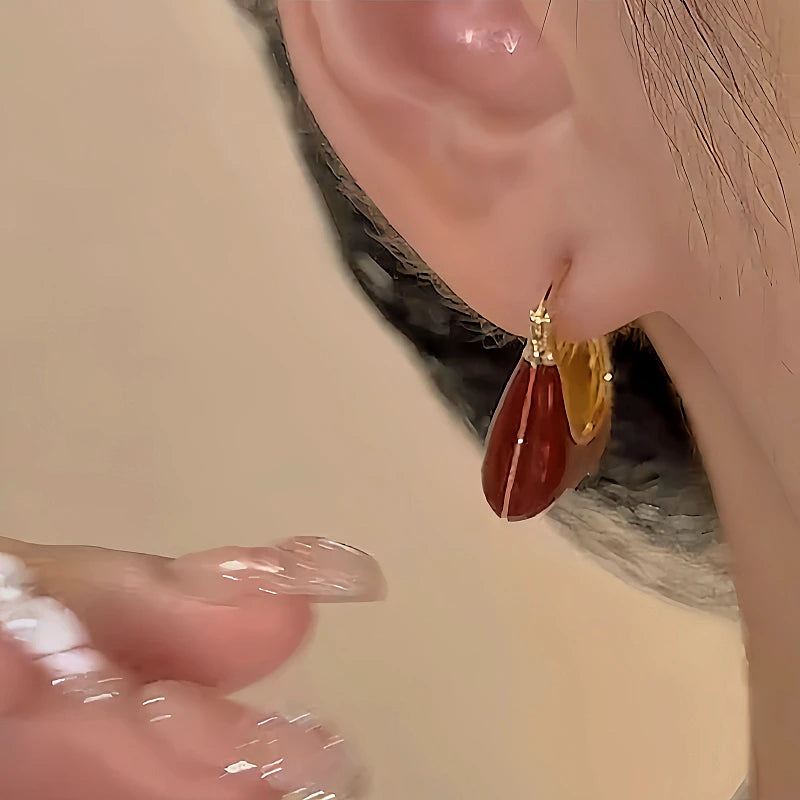 Model showcasing the dangle and style of the 14K Gold-Plated Oil Drop Handbag Earrings