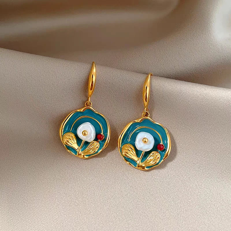 Teal enamel gold floral drop earrings with pearl on folded beige satin