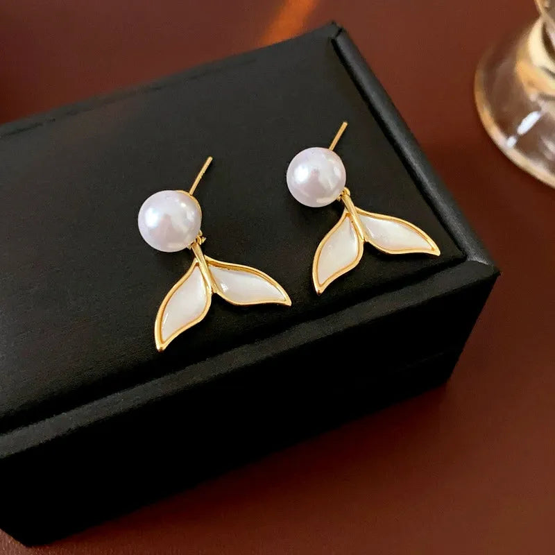Pair of pearl mermaid tail drop earrings on black jewelry box
