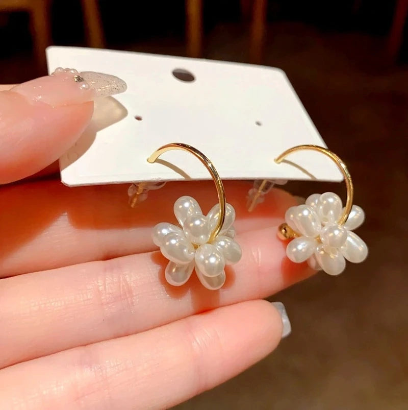 Pair of pearl flower gold hoop earrings on white earring display card