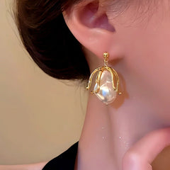 Model showcasing the dangle and style of the 14K Gold-Plated Pearl Flower Earrings