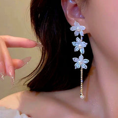 Model showcasing the dangle and style of the 14K Gold-Plated Pearl Flower Tassel Earrings