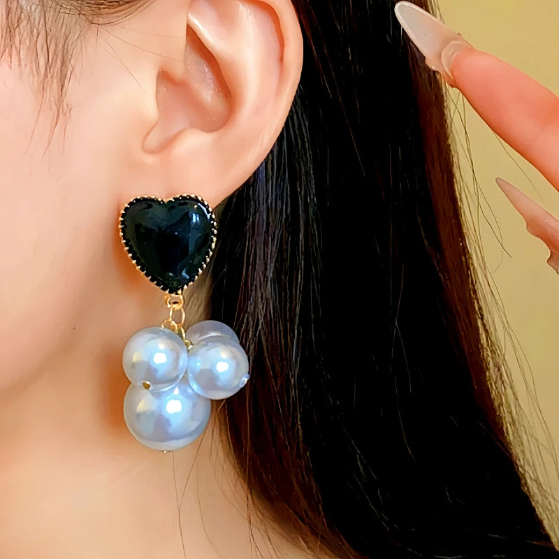 Model showcasing the dangle and style of the 14K Gold-Plated Pearl Heart Earrings