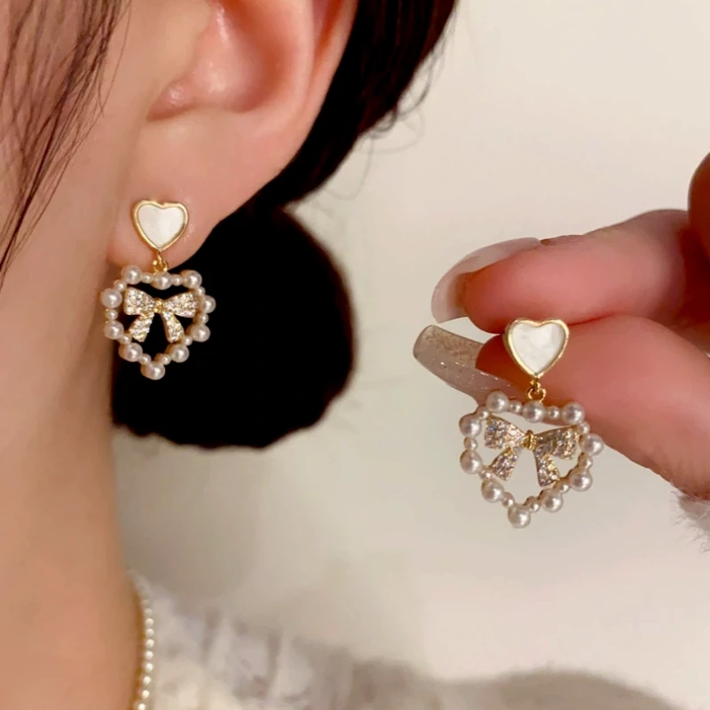 Angled view of the 14K Gold-Plated Pearl Heart Zircon Bow Earrings