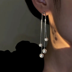 Model showcasing the dangle and style of the 14K Gold-Plated Pearl Tassel Earrings