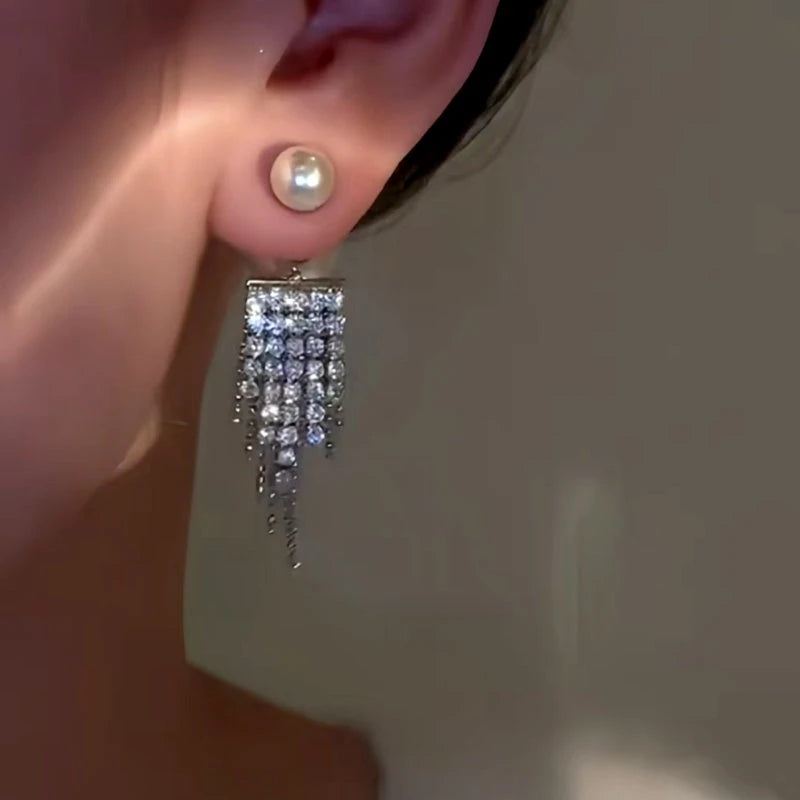 Model showcasing the dangle and style of the 14K Gold-Plated Pearl Zircon Tassel Earrings