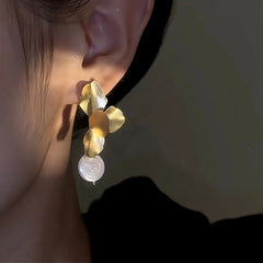 Model showcasing the dangle and style of the 14K Gold-Plated Petal Flower Pearl Earrings