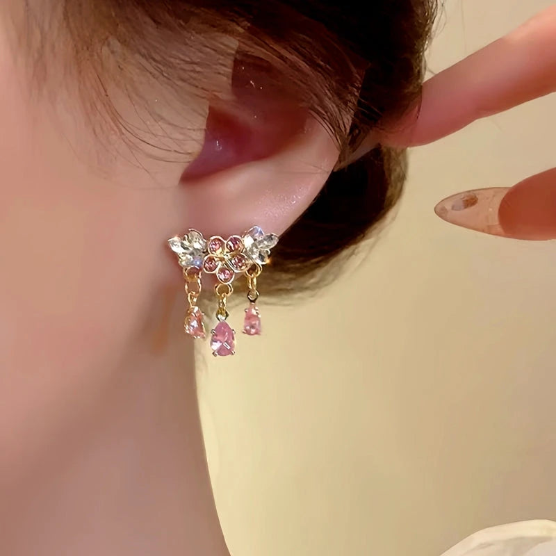 Model showcasing the dangle and style of the 14K Gold-Plated Pink Diamond Flower Earrings