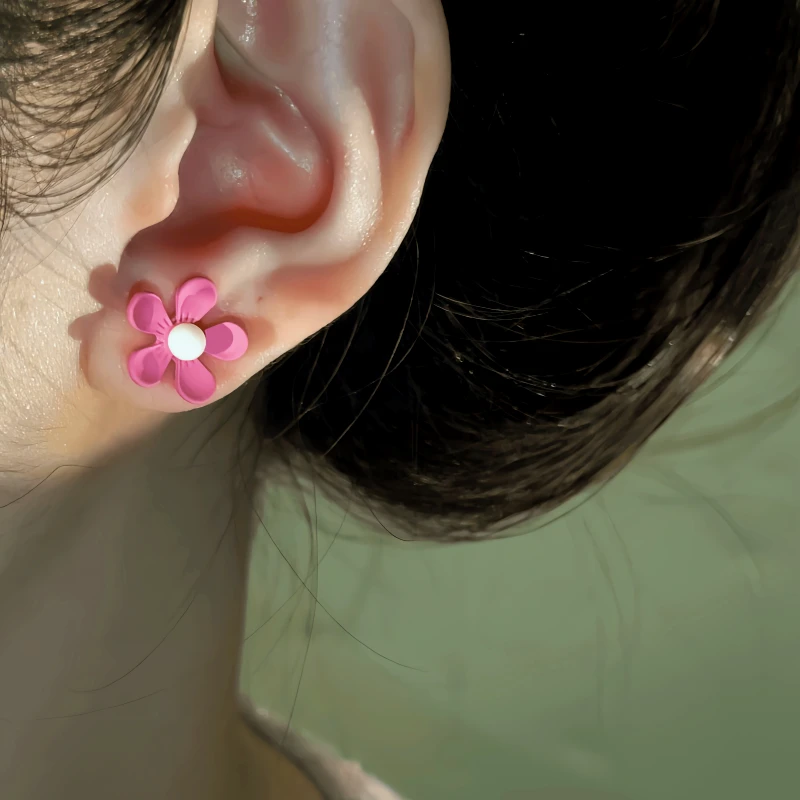 Model showcasing the dangle and style of the 14K Gold-Plated Pink Flower Stud Earrings