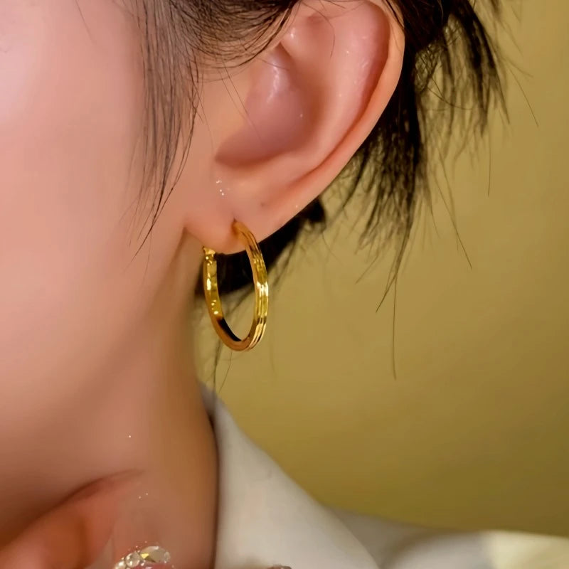 Model showcasing the dangle and style of the 14K Gold-Plated Plan Hoop Earrings