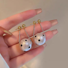 Gold stud dangle earrings with white polka dot textured pearl ball drops on chains