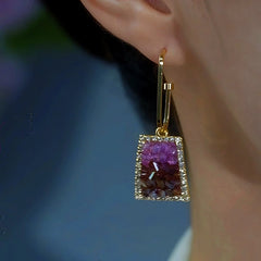 Gold gradient purple-brown crystal drop earring worn on ear side view