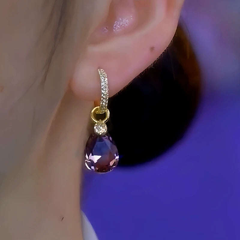 Model showcasing the dangle and style of the 14K Gold-Plated Purple Crystal Water Drop Earrings