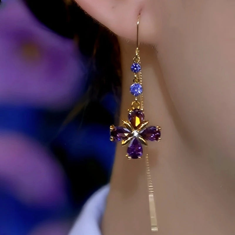 Purple crystal flower gold drop earring worn on ear, side view