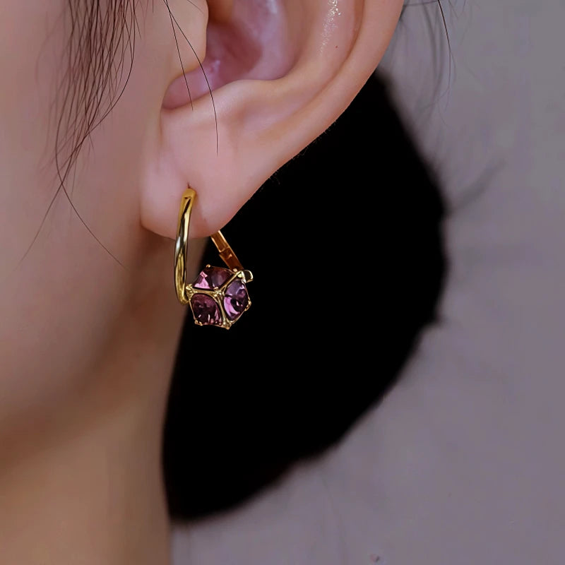 Gold purple cubic gem hoop earring on woman's left ear, side view