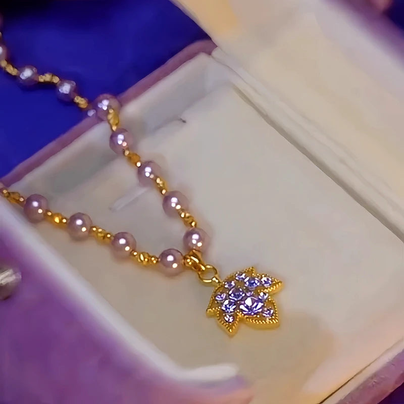 Detailed view of the 14K Gold-Plated Purple Diamond Maple Leaf Pearl Necklace chain and pendant