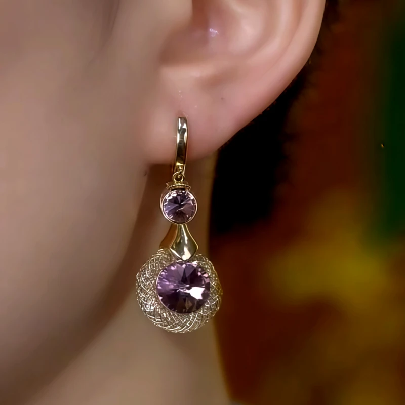 Gold purple crystal woven drop earring worn on earlobe