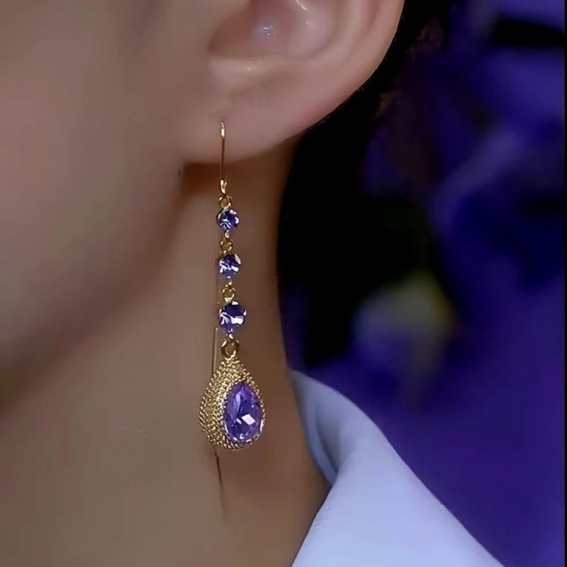 Gold purple crystal teardrop drop earring worn on ear side view