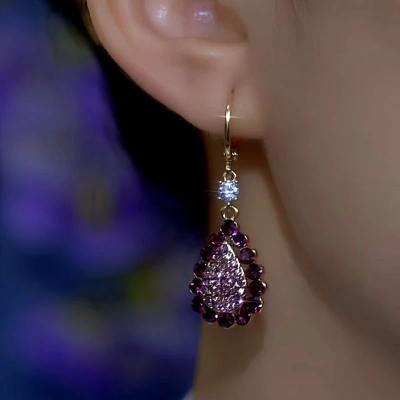Matching purple teardrop rhinestone gold hoop drop earring on woman's ear