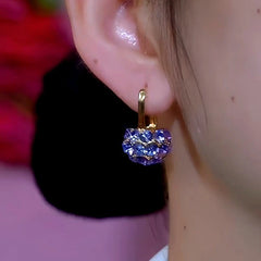 Gold purple crystal drop hoop earring worn on ear, side angle close-up