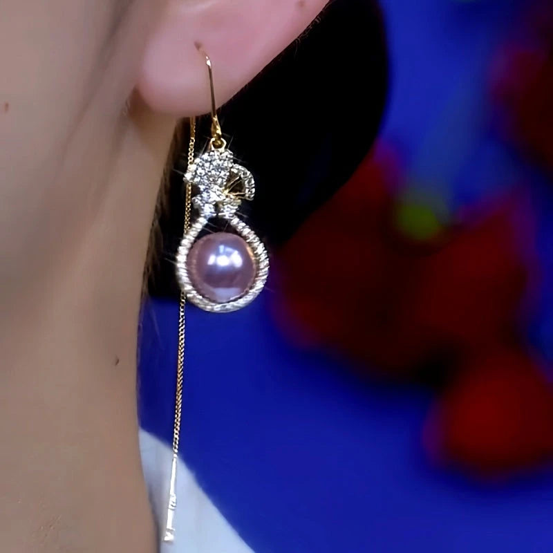 Purple pearl gourd tassel dangle earring worn on female ear, side view