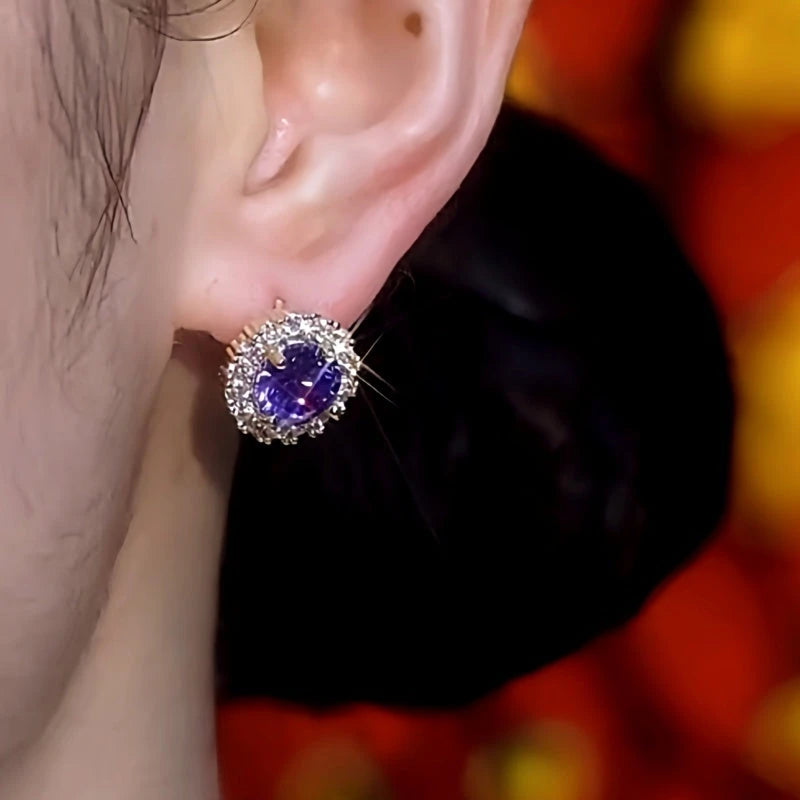 Angled view of purple gemstone halo stud earring on earlobe