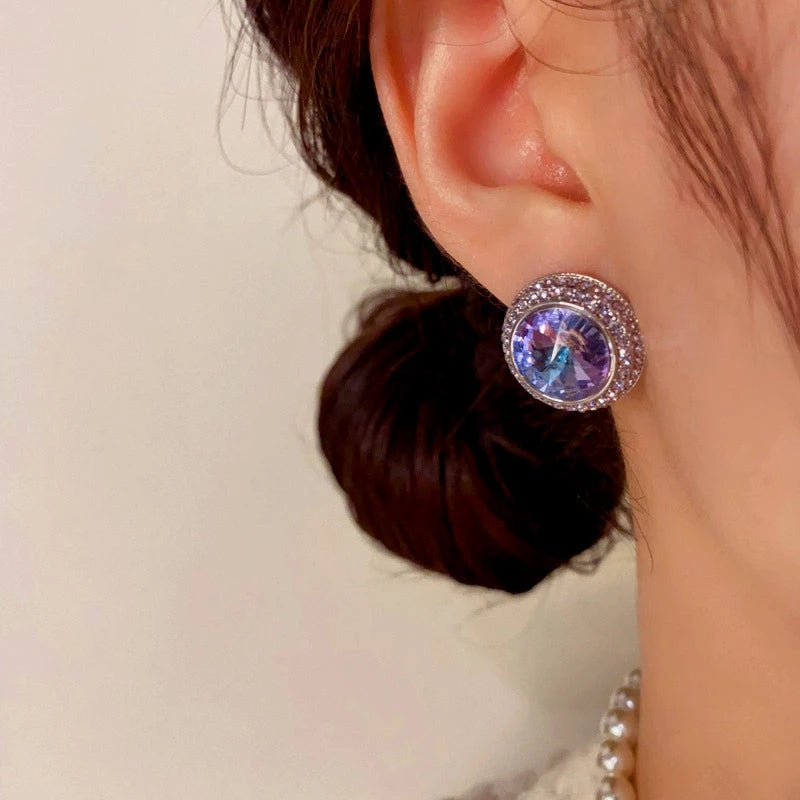 Purple-blue gradient crystal halo stud earring worn on woman's ear