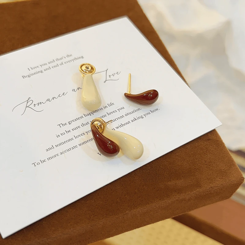 Glossy two-tone cream and burgundy resin drop earrings with gold hardware on romantic quote card