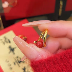 Gold huggie hoop earring with red bead, women's festive fashion jewelry