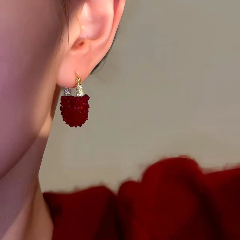 Model showcasing the dangle and style of the 14K Gold-Plated Red Crystal Earrings