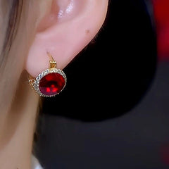 Model showcasing the dangle and style of the 14K Gold-Plated Red Crystal Earrings