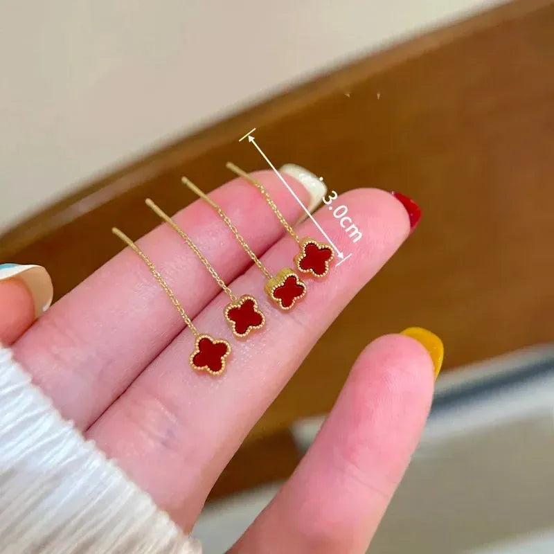 Model showcasing the dangle and style of the 14K Gold-Plated Red Four-Leaf flower Threader Earrings