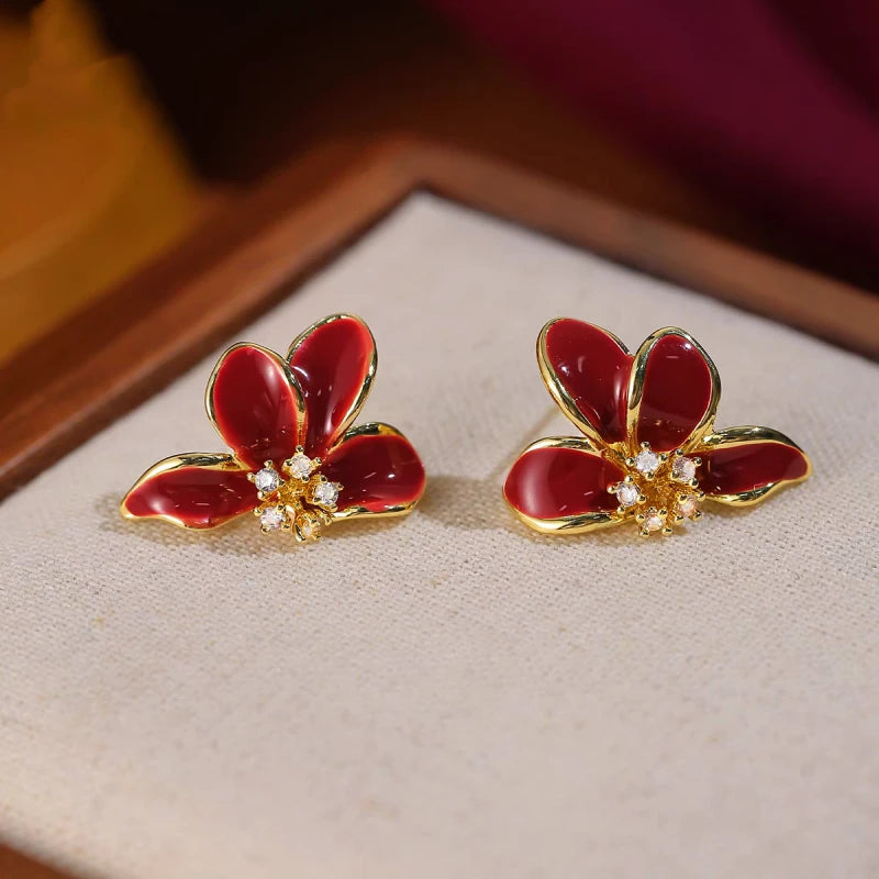 Angled view of the 14K Gold-Plated Red Glaze Flower Earrings