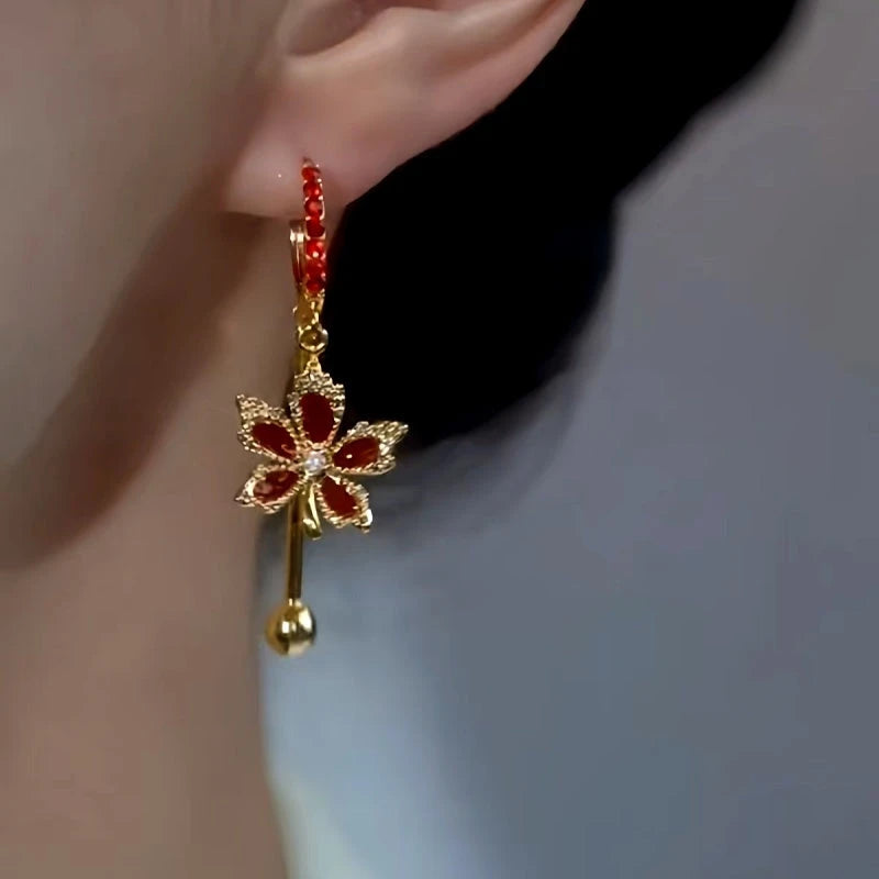 Model showcasing the dangle and style of the 14K Gold-Plated Red Maple Leaf Tassel Earrings