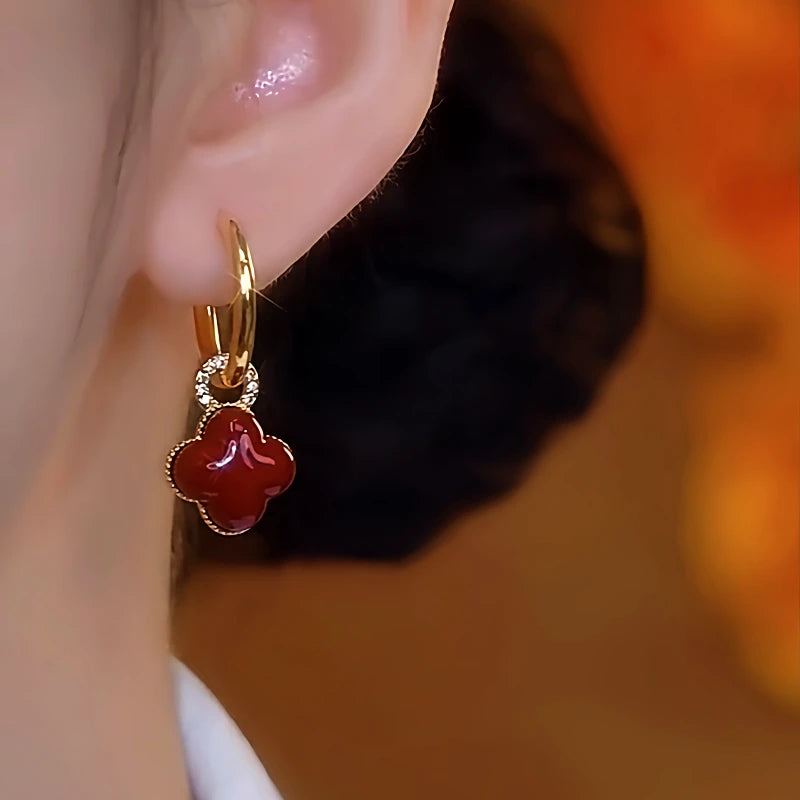 Model showcasing the dangle and style of the 14K Gold-Plated Red Oil-Drop Four-Leaf Clover Earrings