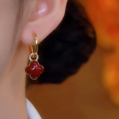 Model showcasing the dangle and style of the 14K Gold-Plated Red Oil-Drop Four-Leaf Clover Earrings